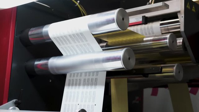 Close up Large offset printing press. moving polymer label conveyor typography facility and flexographic printing