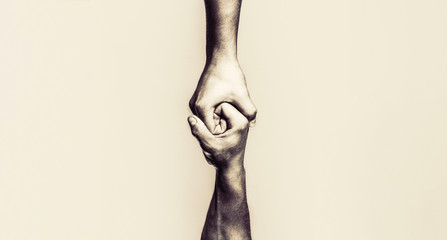 Two hands, helping arm of a friend, teamwork. Helping hand outstretched, isolated arm, salvation. Close up help hand. Black and white. Copy space