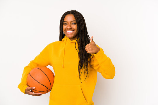 Young african american woman playing basketball isolated smiling and raising thumb up