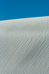 Background or Texture image with close-up of wave patterns on white gypsum dunes at White Sands National Park