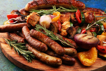 Assorted delicious grilled meat with vegetable on a barbecue with Grilled pork shish or kebab on skewers with vegetables.