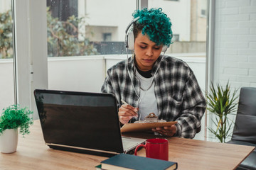 girl with computer and headphones at home or office desk