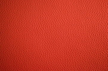 Leather texture close up. Orange fashionable background, top view. Stylish coral wallpaper with rough surface.