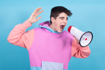 young teenage man or student with megaphone isolated on background with shout expression