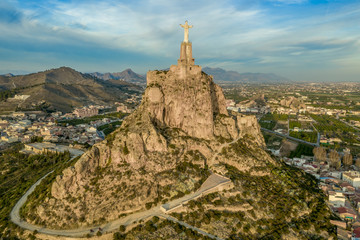 Monteagudo medieval castle ruin twelve rectangular towers circling the hilltop and the sacred heart of Jesus Christ statue on top near Murcia Spain