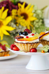 Colorful cupcakes and floral arrangement with sunflowers and hortensias