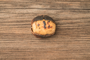 closeup a roasted chestnut on a wooden table