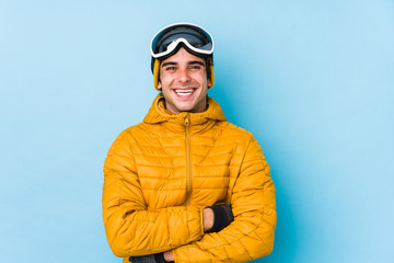Young skier man wearing snowboard goggles isolated laughing and having fun.