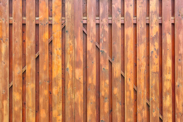 A fragment of a painted wooden gate. The structure of the boards and battens. Brown surround background for layouts.