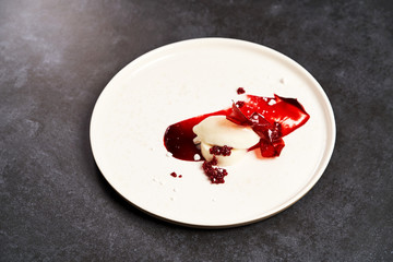 Raspberry Sorbet on a white plate, close-up. Raspberry ice cream with sweet syrup