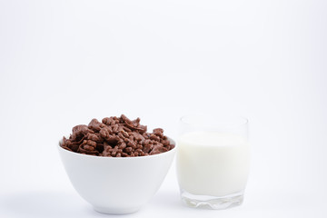 Breakfast cereal, cornflake chocolate in cups and milk is a healthy breakfast that is healthy for the body every day on a white background.
