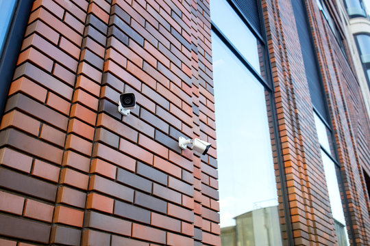 CCTV camera on the wall.  Private property protection. Camera in office building. Modern security technology. Industrial design in city architecture. ..