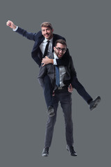 happy businessman carrying his colleague on the piggyback