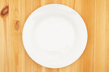 White empty plate on a wood table