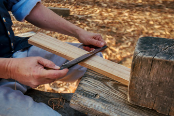 Shaping wood with a draw knife.