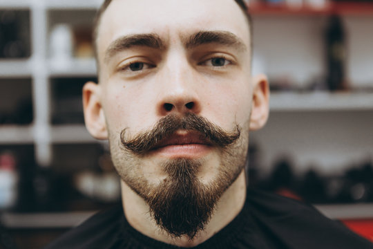 portrait of a satisfied barber shop customer who came to change his beard shape