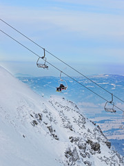Fototapeta na wymiar Chair lifts with passengers in Kasprowy Wierch in Zakopane in winter. Zakopane is a town in Poland in Tatra Mountains.Kasprowy Wierch is mountain in Zakopane and is the most popular ski area in Poland