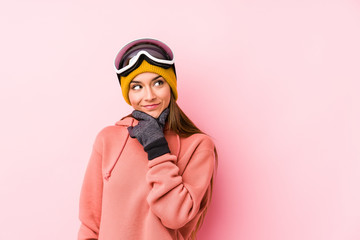 Young caucasian woman wearing a ski clothes isolated looking sideways with doubtful and skeptical expression.