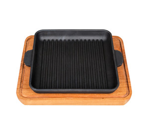 Square, cast iron frying pan on a wooden stand. On white background.