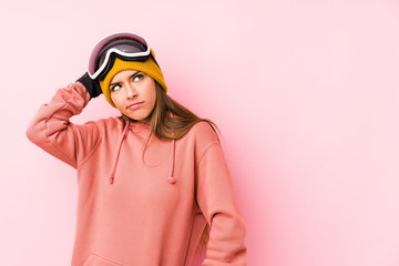 Young caucasian woman wearing a ski clothes isolated touching back of head, thinking and making a choice.