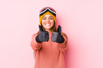 Fototapeta premium Young caucasian woman wearing a ski clothes isolated with thumbs ups, cheers about something, support and respect concept.