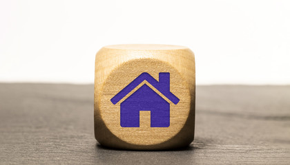 Icone maison / immobilier gravé sur un cube en bois, isolé sur une ardoise