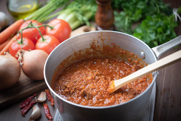 bolognaise sauce in pot with ingredients background - obrazy, fototapety, plakaty