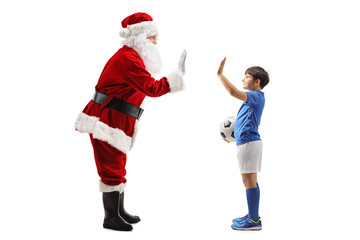  Santa Claus gesturing high-five with a boy in a football outfit