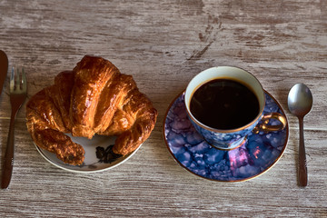 Croissant and coffee in a vintage cup
