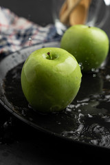 Photography of Verdews apples in black and water background
