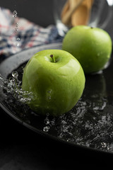 Photography of Verdews apples in black and water background
