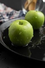 Photography of Verdews apples in black and water background