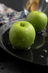 Photography of Verdews apples in black and water background
