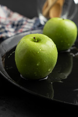 Photography of Verdews apples in black and water background