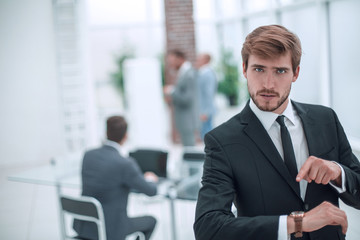 serious businessman pointing to his wrist watch.