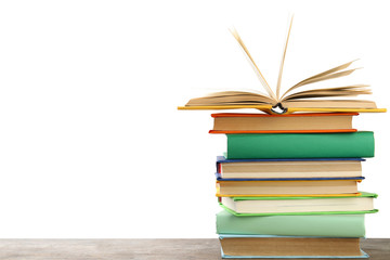 Stack of colorful books on wooden table against white background
