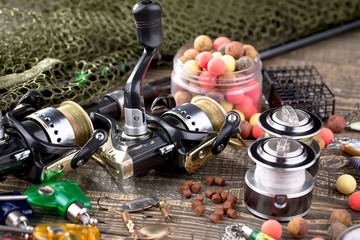 Fishing rods and spinnings in the composition with accessories for fishing on the old background on...