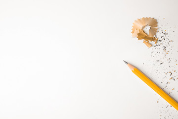 Pencil and shavings on white background, top view