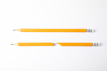 Fototapeta premium Broken and whole graphite pencils on white background, top view