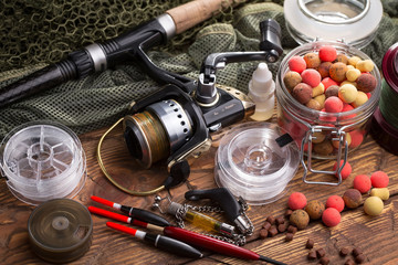 fishing tackle on a wooden table. toned image
