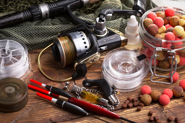 Fishing rods and spinnings in the composition with accessories for fishing on the old background on...