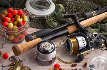 Fishing rods and spinnings in the composition with accessories for fishing on the old background on...