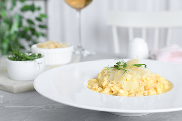 Delicious risotto with cheese on grey marble table indoors