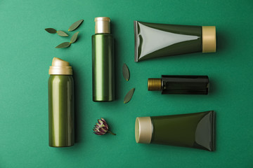 Flat lay composition with cosmetic products on green background