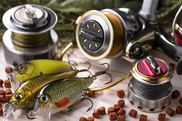 Fishing rods and spinnings in the composition with accessories for fishing on the old background on...