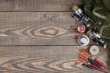 Fishing rods and spinnings in the composition with accessories for fishing on the old background on...