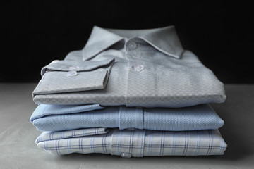 Stack of classic shirts on light stone table