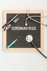 Text phrase Coronavirus syringe and stethoscope on black letter board background. Novel coronavirus 2019-nCoV, MERS-Cov middle East respiratory syndrome coronavirus originating in Wuhan China