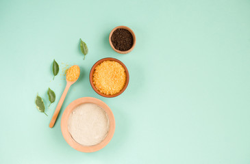 Cosmetic bath salt, grape gomaj for the face, coffee scrub for the body on a mint background. Spa...