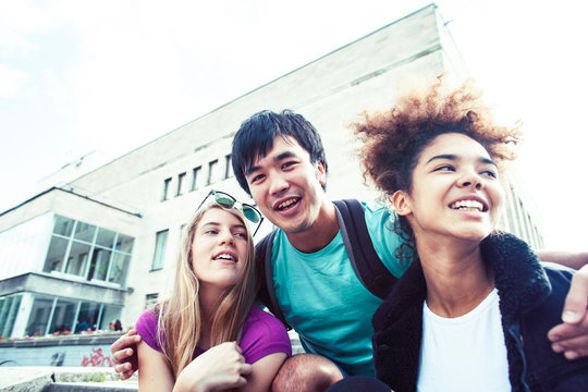 Cute Group Of Teenages At The Building Of University With Books Huggings, Diversity Nations Real Students Lifestyle